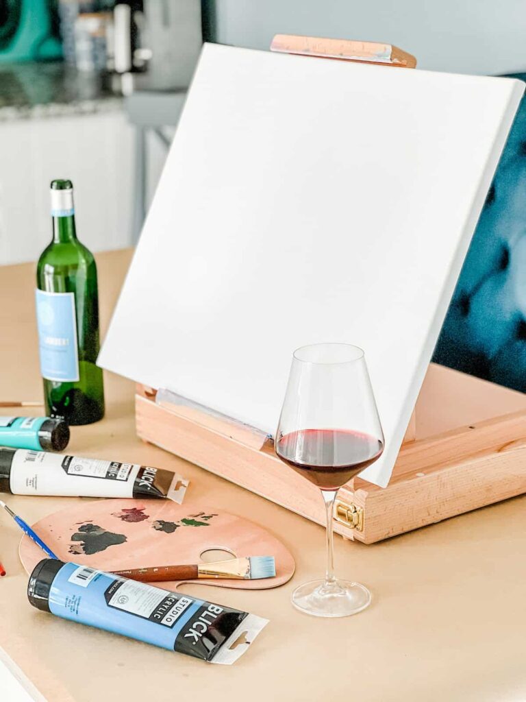 Blank canvas on easel with painting supplies