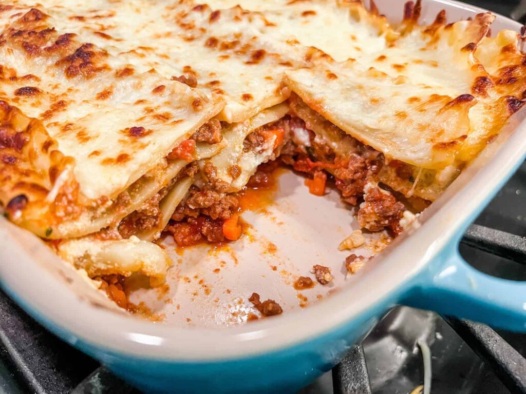 Lasagna in a baking dish with one slice removed
