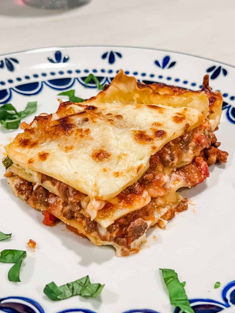 Slice of lasagna on a plate with basil