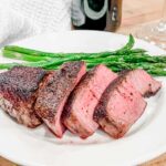 Filet mignon sliced on a plate with asparagus