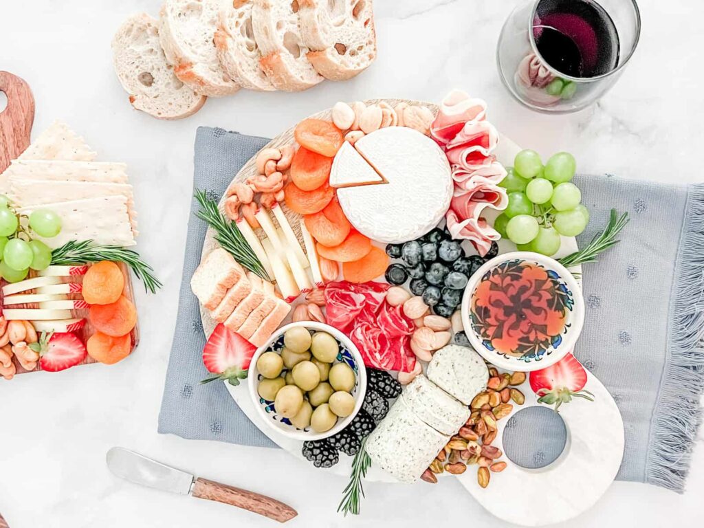 Small Charcuterie board for two people with red wine and sliced bread