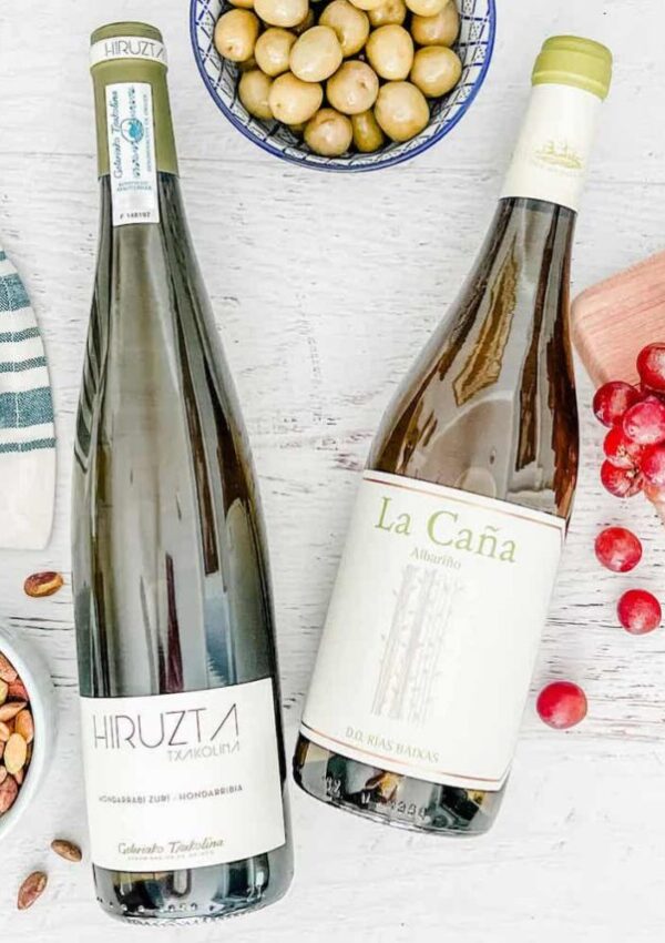 Bottles of Spanish white wine with grapes, olives, and nuts