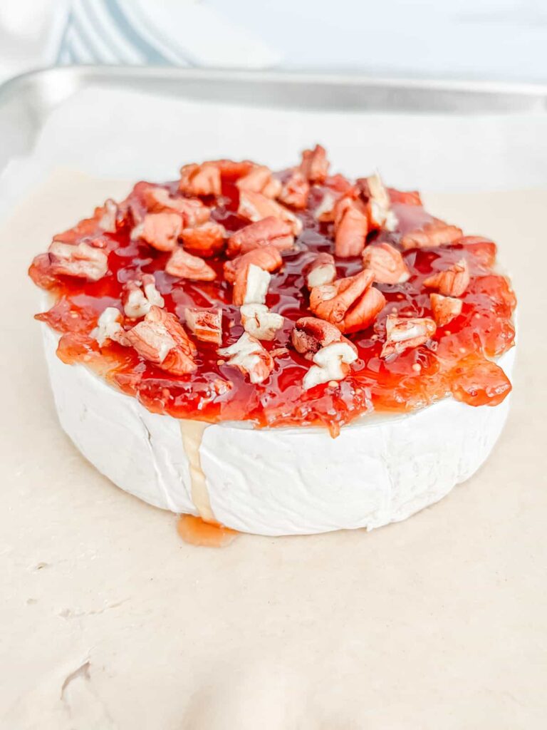 Brie topped with jam, nuts, and honey