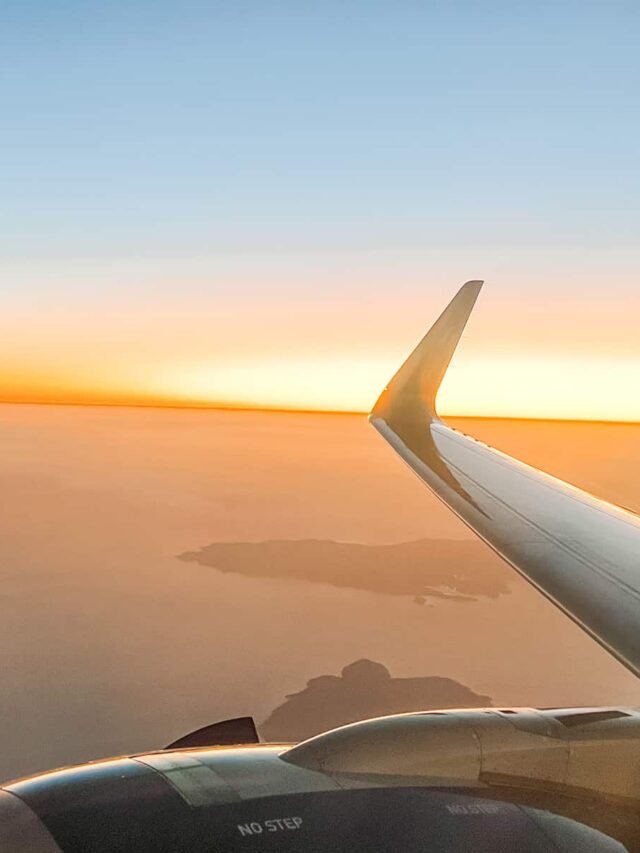 Airplane wing with a sunrise in the background