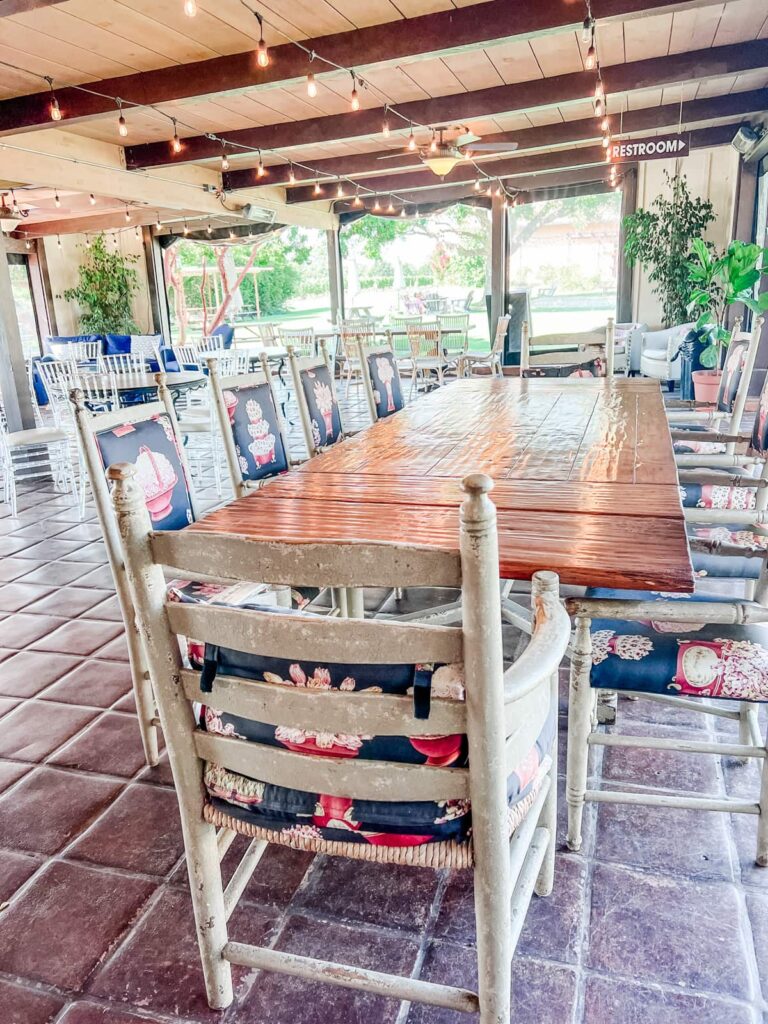 Rustic indoor seating area of Rideau tasting room with a large wooden table and string lights.