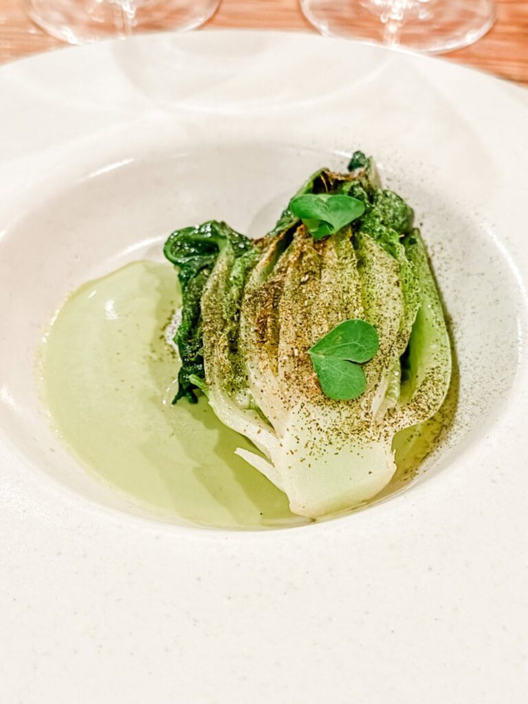 Plated dish of Deer tongue lettuce with lovage and miso, served in a light green sauce and garnished with herbs at Espace Old Mill.