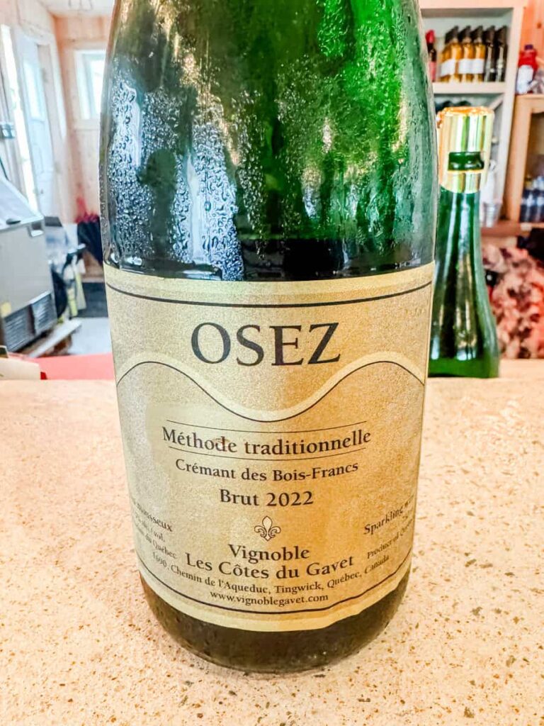Close-up of a bottle of OSEZ Brut 2022 from Vignoble Les Côtes du Gavet, labeled as a Méthode Traditionnelle Crémant des Bois-Francs.