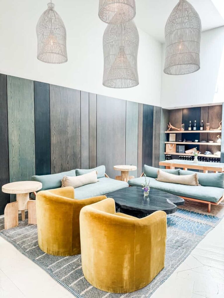 Modern wine tasting lounge area at Marine Layer with velvet chairs, minimalist decor, and elegant hanging lamps.