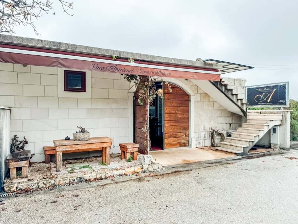 Exterior entrance of Antičević winery with stone façade and wooden door on Pelješac Peninsula.