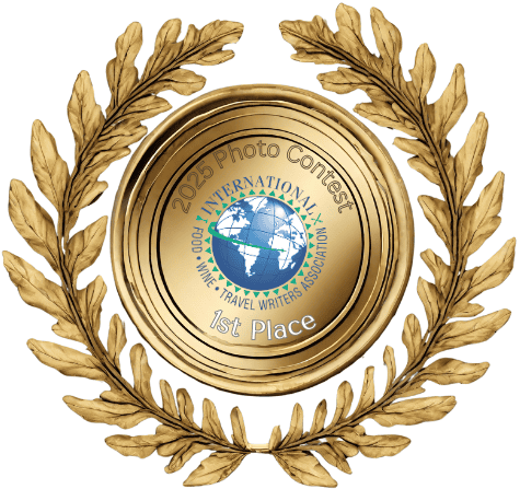 Gold medallion with IFWTWA globe logo and text overlay around it saying "2025 Photo Contest - 1st Place"