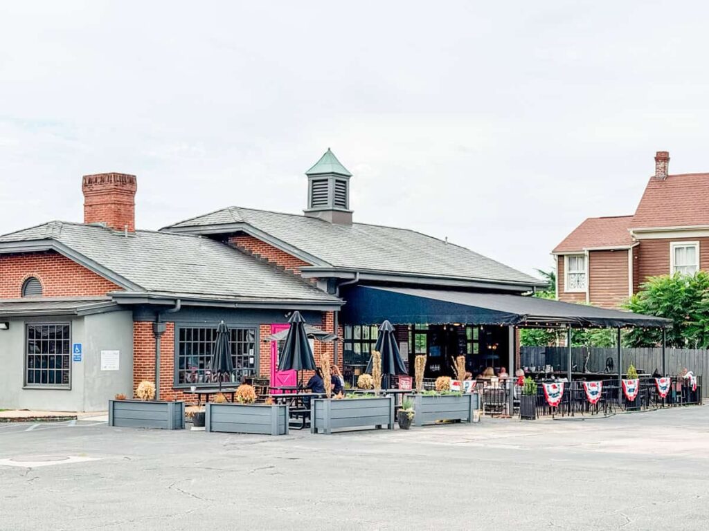 Exterior of Crema & Vine with a covered patio, outdoor seating, and brick building in Danville.