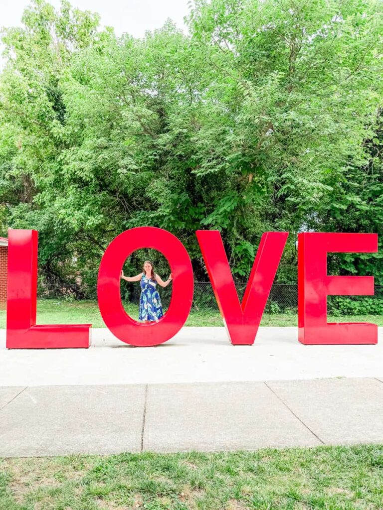 Laura standing inside the giant red LOVE sculpture in Danville's River District.