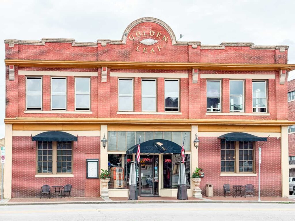 Historic red brick building with black awnings at the entrance to Golden Leaf Bistro in Danville.