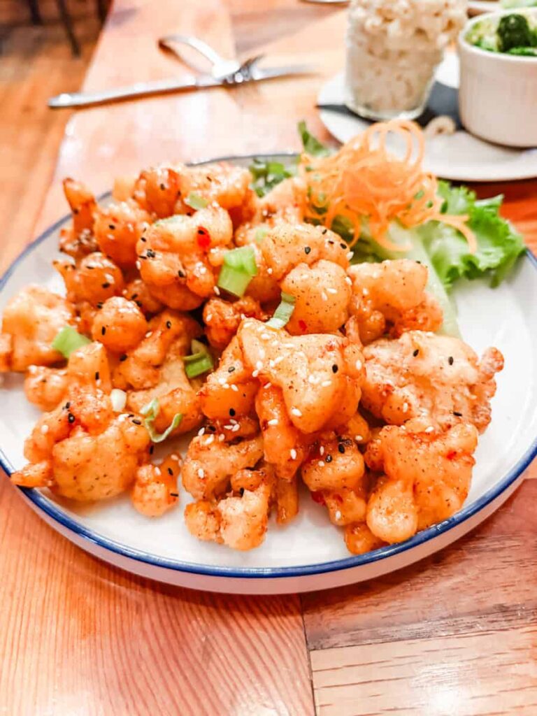 Crispy fried cauliflower tossed in a sweet and spicy sauce with sesame seeds and green onions at King Cropp Kitchen.