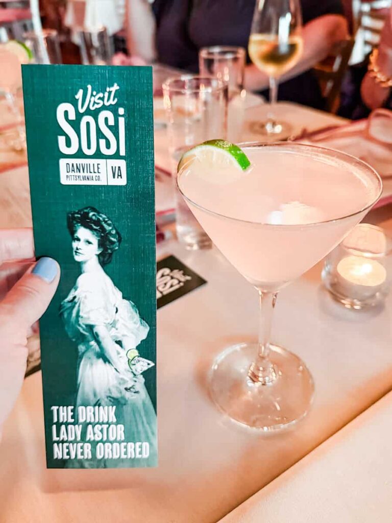 Lady Astor martini with a lime wedge served beside a bookmark that reads "Visit SoSi Danville VA Pittsylvania Co. The drink Lady Astor never ordered."