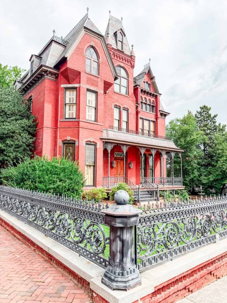 Historic red brick Victorian mansion with decorative iron fencing in Danville's Old West End.