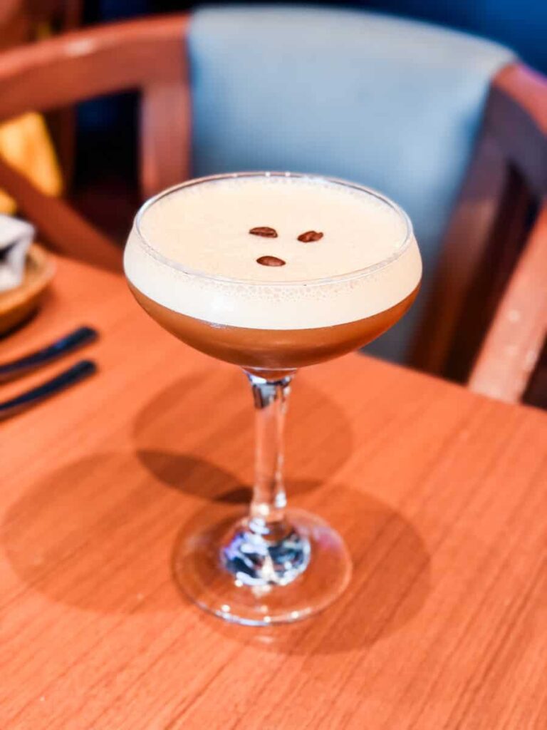 Espresso martini with a foamy top and three coffee beans served during a mixology demonstration at Ramsay's Kitchen.