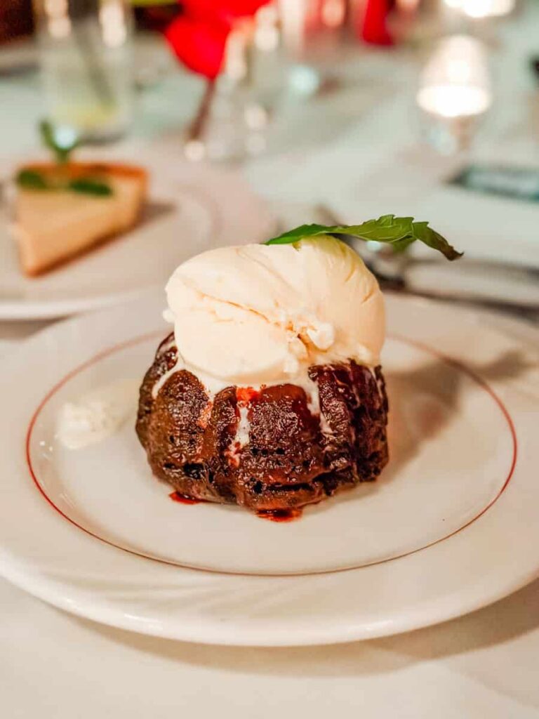Warm chocolate dessert topped with a scoop of vanilla ice cream and a fresh mint leaf on a white dessert plate at The Schoolfield Restaurant