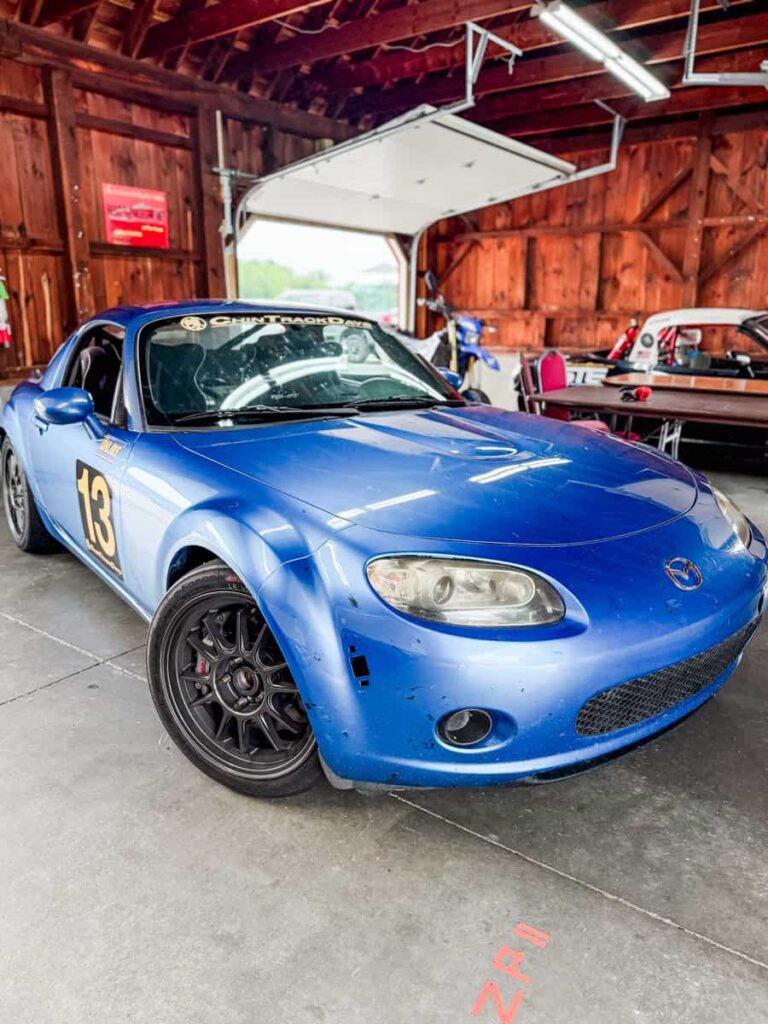 Blue race car with the number 13 parked inside a garage at Virginia International Raceway before heading out for a track session.